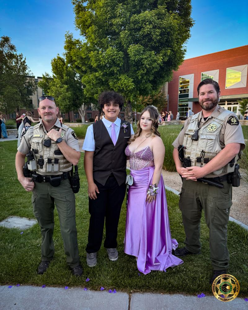 Two MCSO School Resource Officers stand with prom goers.